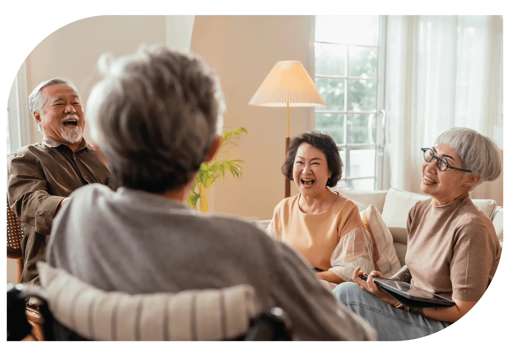 A group of seniors enjoying a joyful moment together in a cozy living room.